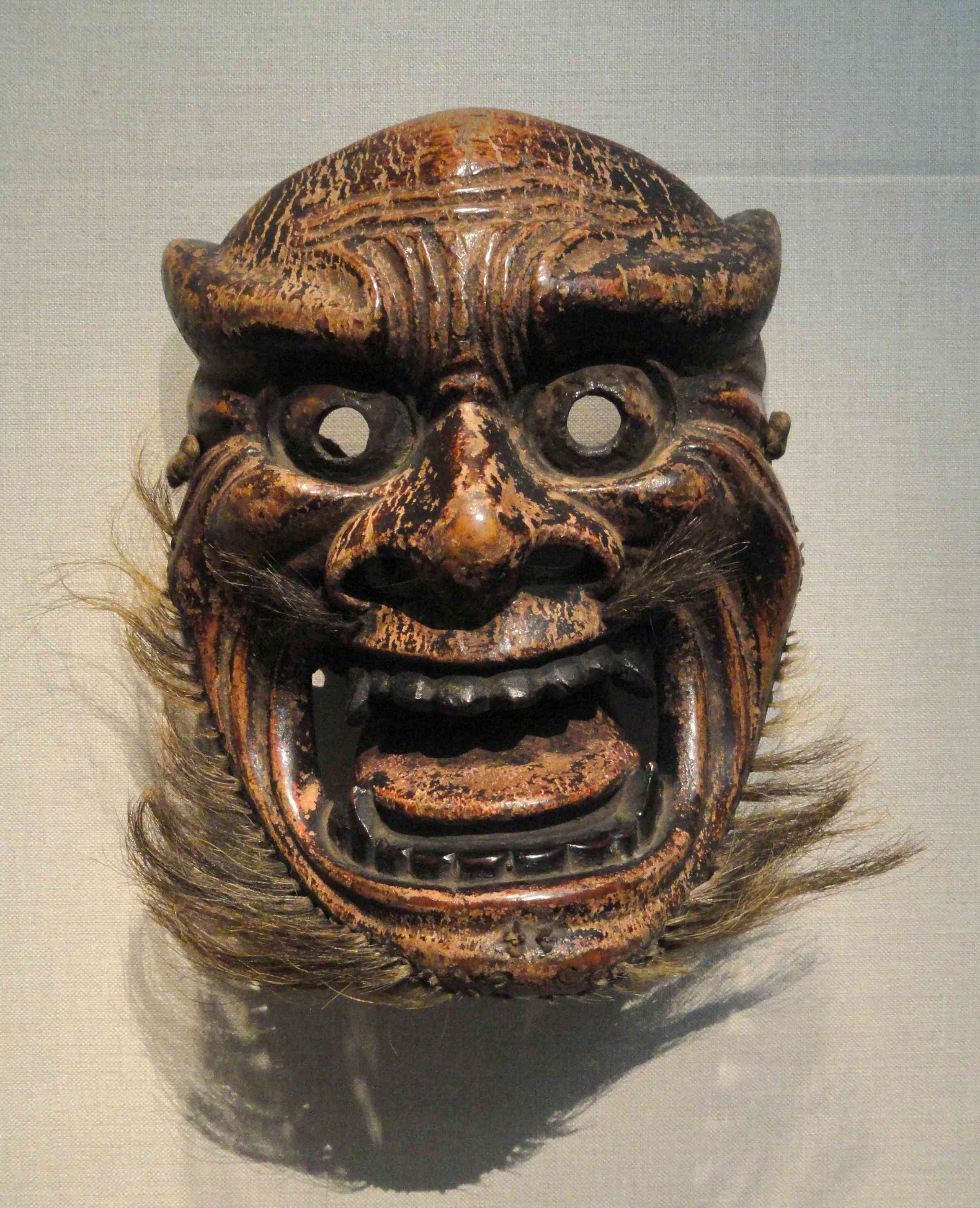 Japanese oni demon mask from the Edo period, carved wood with fierce expression