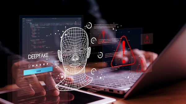 Illustration showing a wireframe human face overlaid on a laptop and smartphone, with code, login fields, warning icons, and the word “deepfake,” representing AI-generated identity manipulation, cybersecurity risks and digital fraud.